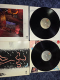 Four vinyl records with their covers on a textured surface